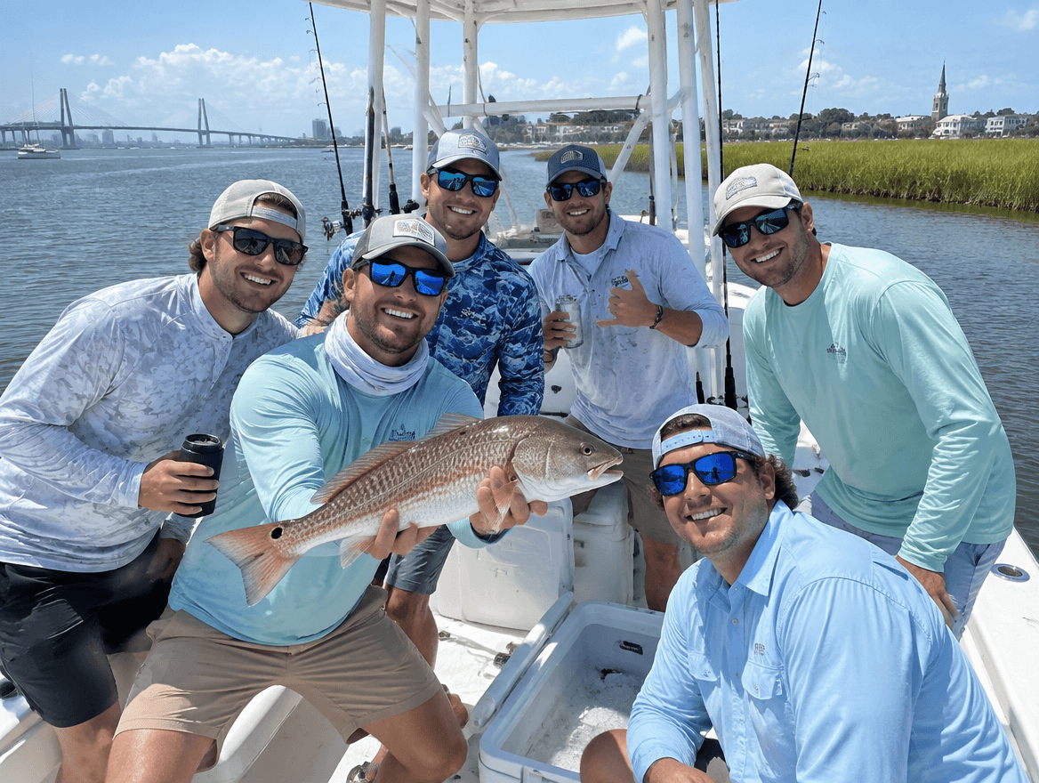 Bachelor party group on a fishing boat near Charleston holding up a redfish